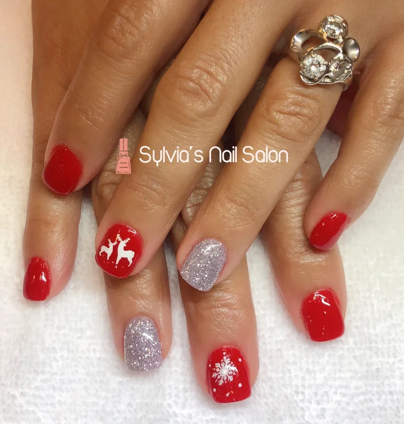 Red holiday nails with a reindeer design and silver glitter accent