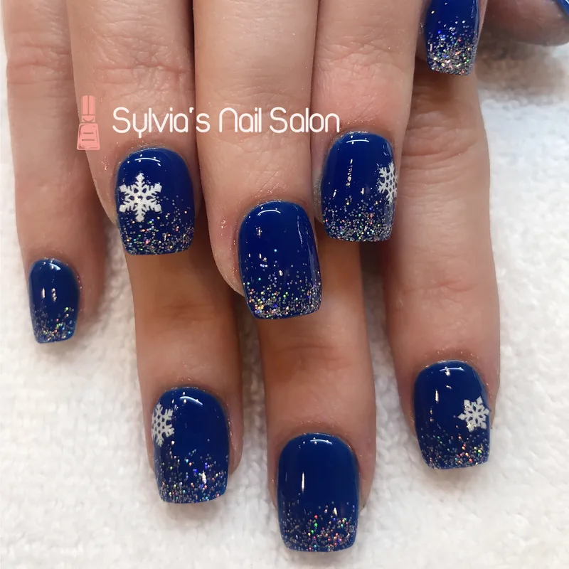 Deep blue glitter nails with a sparkling snowflake design